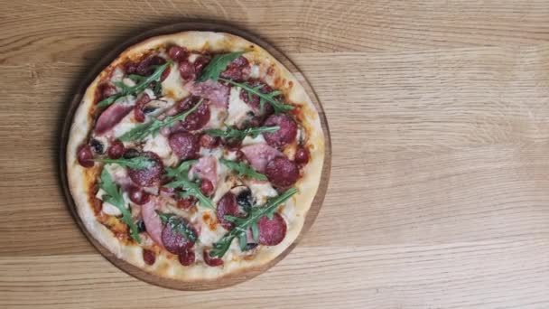 Vista superior de la apetecible pizza en una mesa de madera en un restaurante — Vídeos de Stock