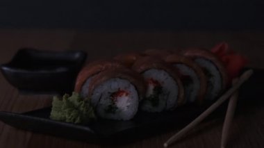 Restoranda ahşap bir masada suşi, lezzetli Japon yemekleri, suşi ruloları.