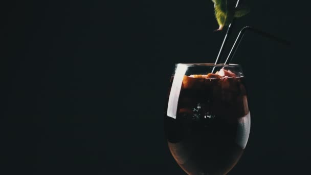 Vin chaud dans un verre avec des pailles au restaurant sur fond noir — Video