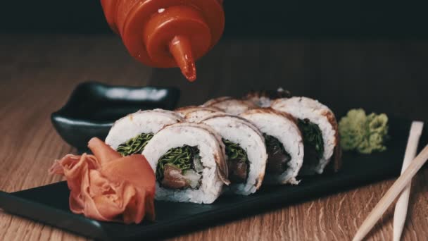 Appetitanregendes Sushi mit süßer Soße auf einem Holztisch im Restaurant — Stockvideo