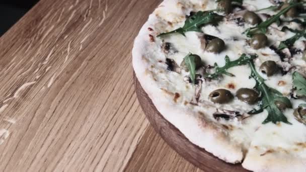 Pizza eten op een houten tafel in een restaurant — Stockvideo