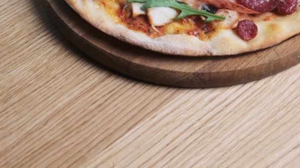 Appetitoso pizza su una tavola di legno in un ristorante — Video Stock