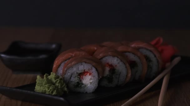 Sushi en una mesa de madera en el restaurante, deliciosa comida japonesa, rollos de sushi — Vídeos de Stock