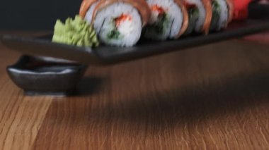 Restoranda ahşap bir masada suşi, lezzetli Japon yemekleri, suşi ruloları.