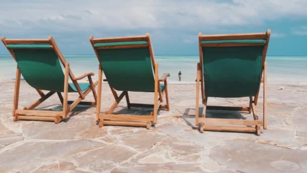 Drei leere Liegestühle stehen in einer Reihe am Meer am Tropical Beach, Rückansicht — Stockvideo