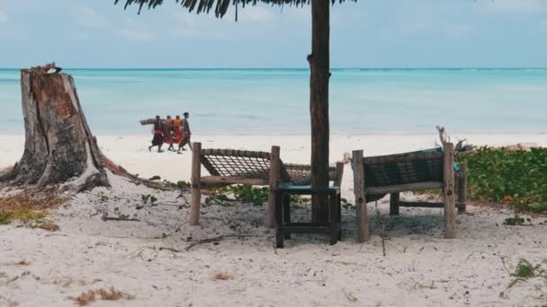 Židle na tropických palubách pod slunečníkem na písečném pobřeží u oceánu, Zanzibar — Stock video