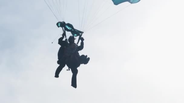 Paracaidistas en tándem Volando en el cielo con un paracaídas. Moción lenta — Vídeo de stock