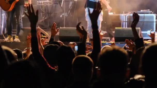 Натовп людей на рок-концерті піднімає руки і аплодисменти, фанати — стокове відео