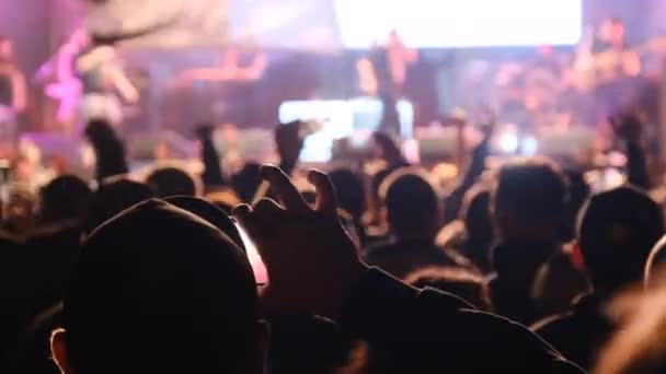 Люди снимают рок на видео, силуэты толпы танцующих фанатов — стоковое видео