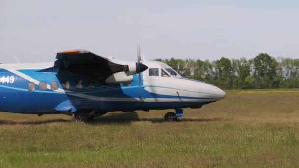 Маленький старый пропеллер движется к взлетно-посадочной полосе в поле для взлета — стоковое видео