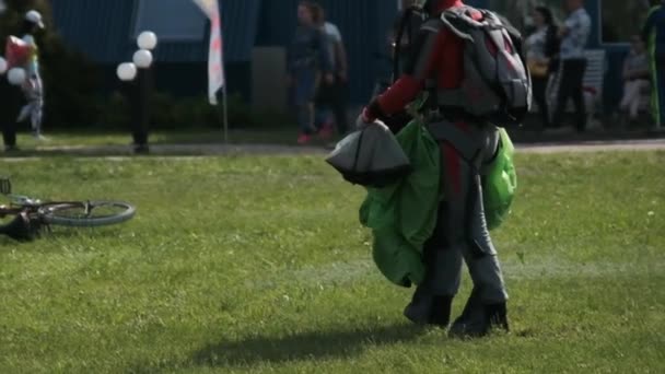 De net geland parachutist met een parachute wandelingen langs de landingsbaan van het vliegveld — Stockvideo