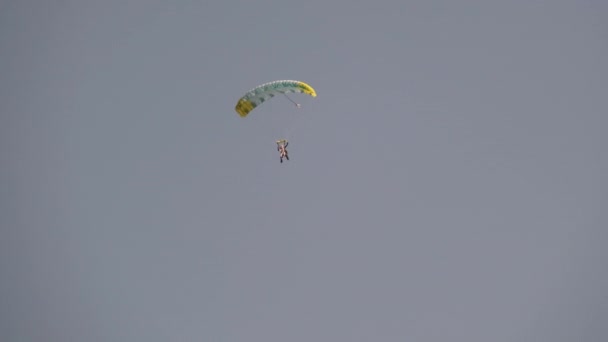 Парашютист летит высоко в небе с парашютом., Прыжок в тандем — стоковое видео