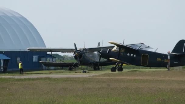 Klein oud propellervliegtuig beweegt in de richting van de startbaan in het veld na de landing — Stockvideo