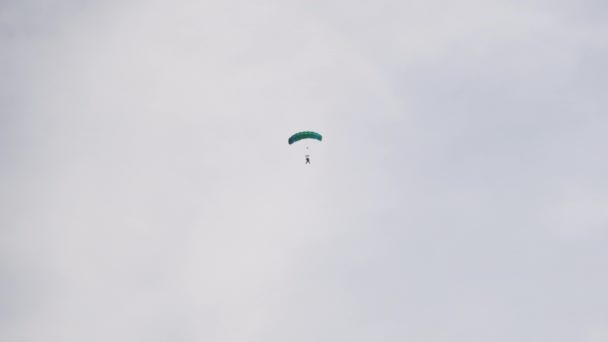 Парашютист летит высоко в небе с парашютом, парашютистом, экстремальным спортом — стоковое видео