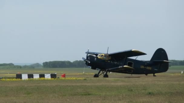 Klein oud propellervliegtuig beweegt in de richting van de startbaan in het veld na de landing — Stockvideo