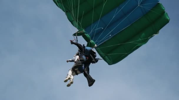 Fallskärmshoppare i Tandem som flyger i himlen med en fallskärm. Långsamma rörelser — Stockvideo