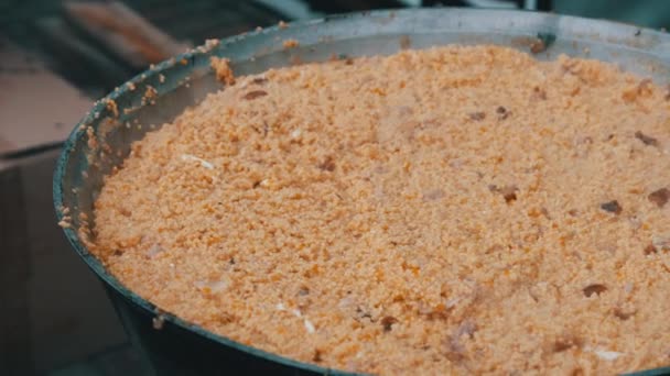 Ετοιμάστε το σιτάρι χυλό σε ένα παραδοσιακό μεγάλο καζάνι πάνω από μια ανοιχτή φωτιά — Αρχείο Βίντεο
