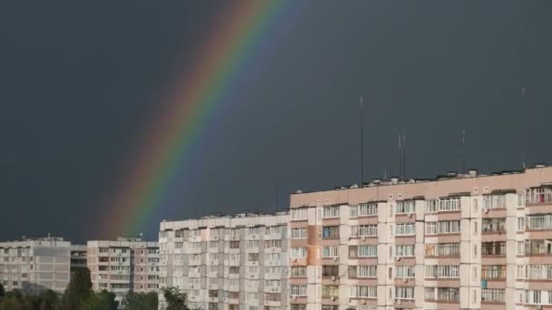 Gran arco iris en el cielo nublado por encima de las casas en la ciudad — Vídeos de Stock