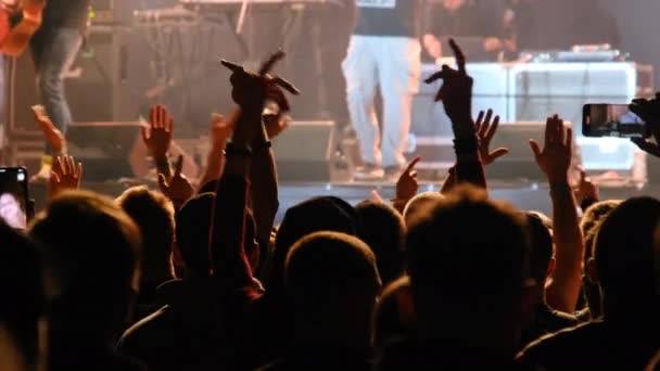 Multitud de personas en un concierto de rock levanta sus manos y aplaude, fans — Vídeos de Stock