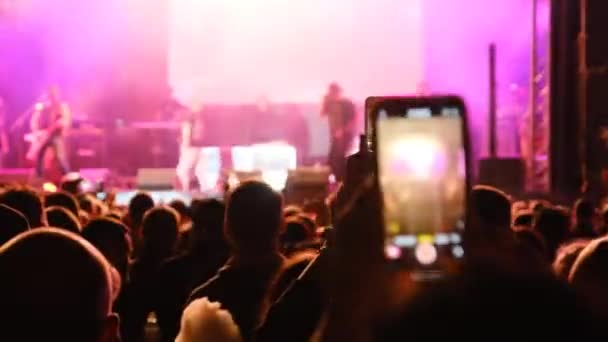 Ludzie filmujący koncert rockowy na smartfonach, sylwetki Tłum fanów tańca — Wideo stockowe