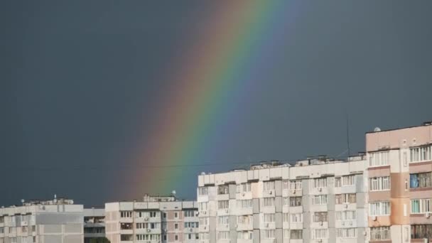Gran arco iris en el cielo nublado por encima de las casas en la ciudad — Vídeos de Stock