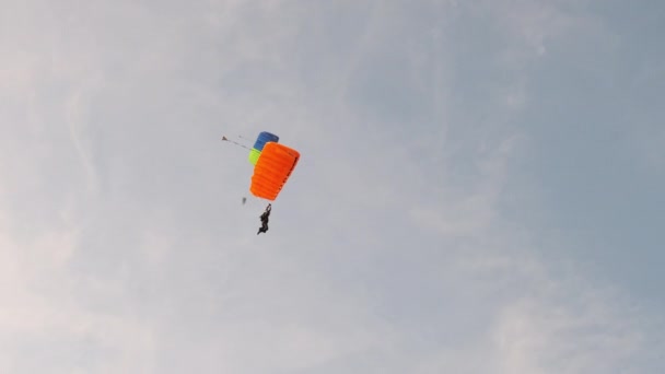 Парашютист летит высоко в небе с парашютом, парашютистом, экстремальным спортом — стоковое видео