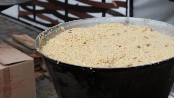 Bereid tarwepap voor in een traditionele grote ketel boven een open vuur — Stockvideo