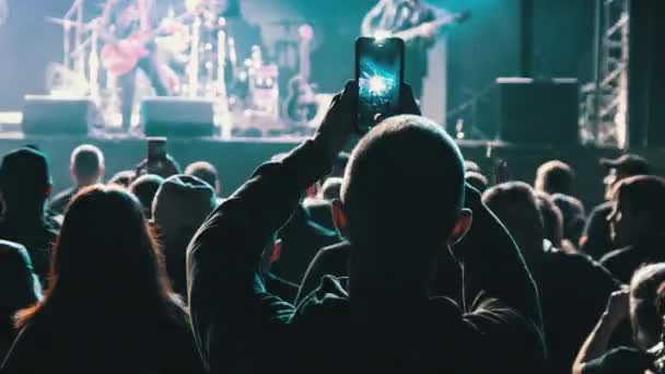 Ludzie filmujący koncert rockowy na smartfonach, sylwetki Tłum fanów tańca — Wideo stockowe