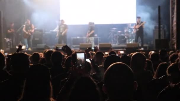 Толпы людей на рок-концерте, фанаты танцуют на музыкальном фестивале под открытым небом — стоковое видео