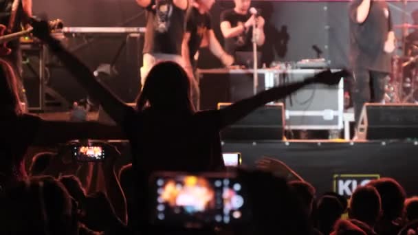 Folkmassa på en rockkonsert höjer sina händer och applåderar, fans — Stockvideo