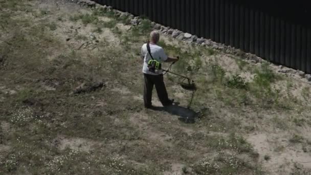 Man klipper gräset med en manuell bensingräsklippare — Stockvideo