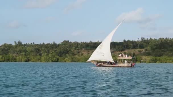 Tradiční africký člun Dhow s turisty plave pod otevřenou plachtou u oceánu — Stock video