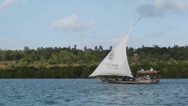 Tradiční africký člun Dhow s turisty plave pod otevřenou plachtou u oceánu — Stock video