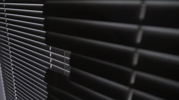 Blinds op een raam in een donkere kamer tegen het licht — Stockvideo
