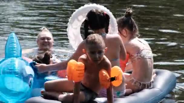 Children Swim and Play on an Inflatable Mattress on the River at Hot Summer Day — Stock Video