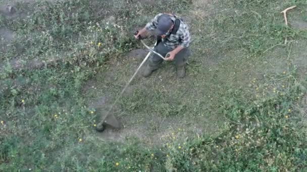 Man klipper gräset med en manuell bensingräsklippare — Stockvideo