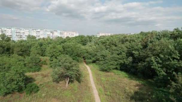 Многоэтажные здания с видом на небо возле зеленого леса в жилом районе города — стоковое видео