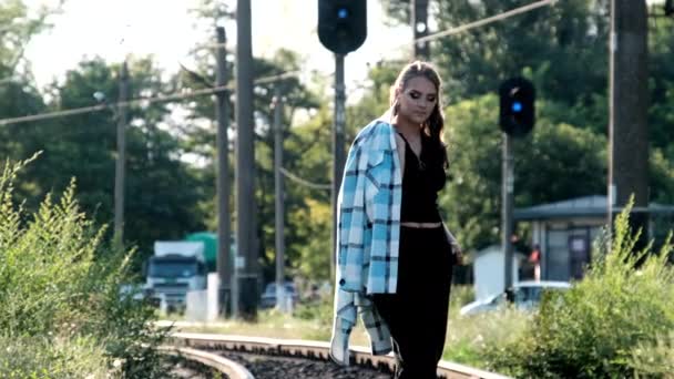 Νεαρή όμορφη γυναίκα περπατά μόνη στην σιδηροδρομική γραμμή — Αρχείο Βίντεο