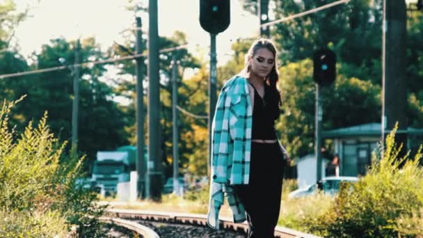 Νεαρή όμορφη γυναίκα περπατά μόνη στην σιδηροδρομική γραμμή — Αρχείο Βίντεο