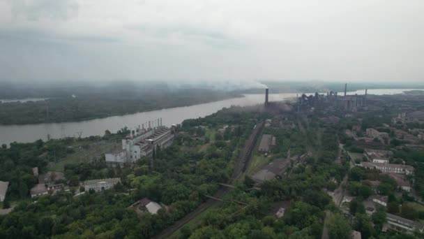 Vista aérea da cidade perto de uma grande planta industrial com tubos e fumaça — Vídeo de Stock
