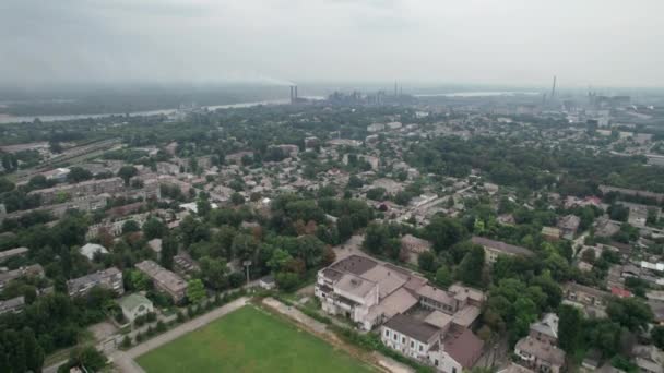 Вид с воздуха на город рядом с крупным промышленным заводом с трубами и дымом — стоковое видео