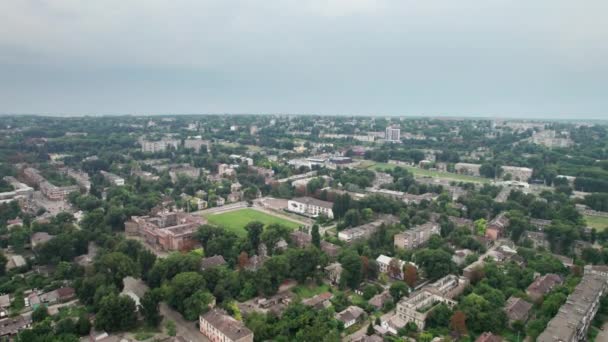 Luftaufnahme einer Kleinstadt, Stadtlandschaft, vorbeifliegende Häuser in der Nähe von Grünflächen — Stockvideo