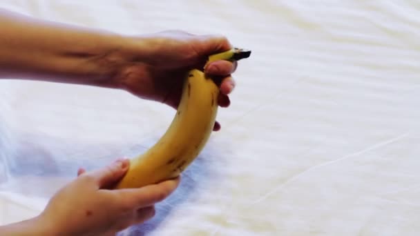 Um homem limpa uma banana — Vídeo de Stock