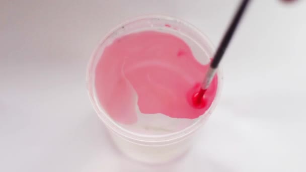 Farbe, die in einem Glas Wasser aufgelöst wird — Stockvideo