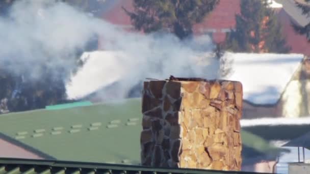 El humo de la chimenea en un fondo de la estación de esquí. De cerca. — Vídeo de stock