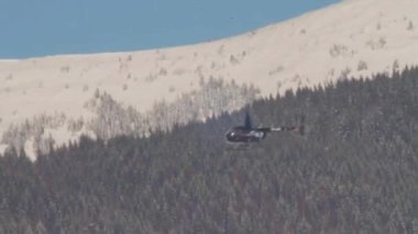Dağ orman üzerinde uçan bir helikopter