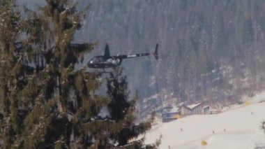 Dağ orman üzerinde uçan bir helikopter