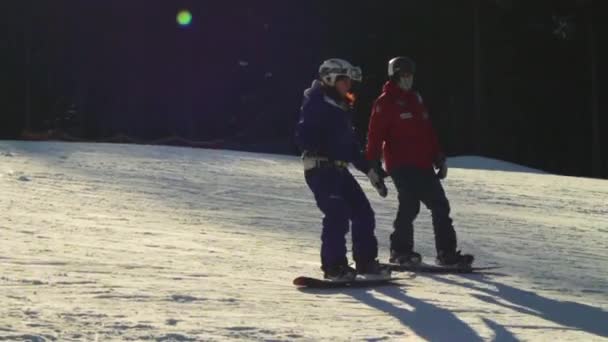 Paseos de esquiador en la pista de esquí con el profesor. Movimiento lento — Vídeos de Stock