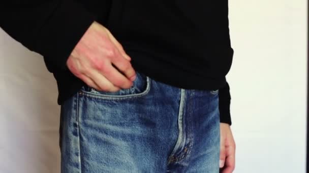 Mann dreht die leeren Taschen seiner Jeans um. Kein Geld. — Stockvideo