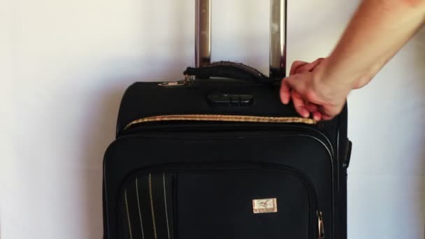 Man buttons zipper on the big suitcase. — Stock Video